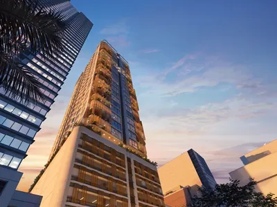 Eluria at dusk on Rada Street, its planted terraces lit against the Makati skyline. Artist's perspective.