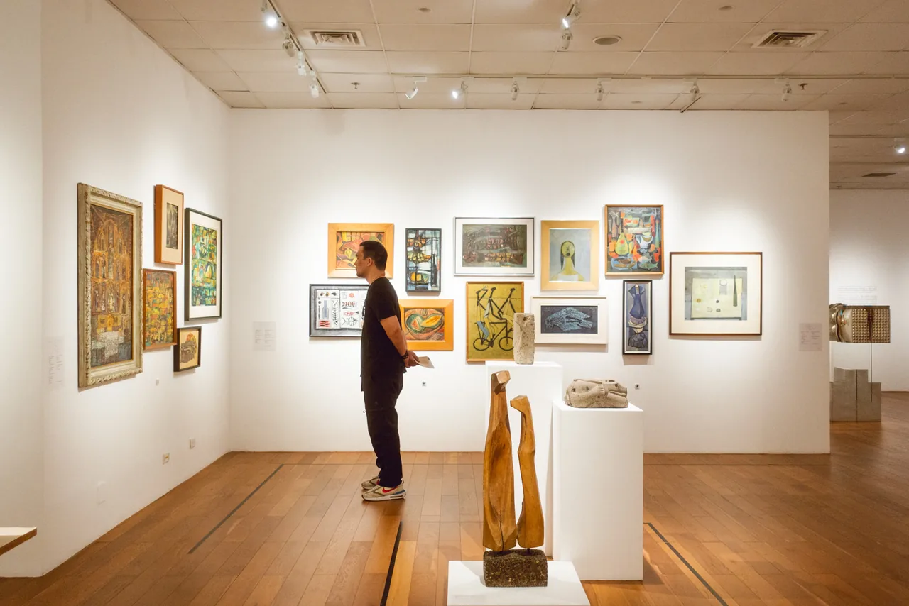 A gallery in the Katipunan area, a visitor looking at hung work.