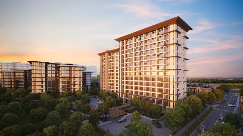 The Una Apartments towers at Sevina Park at golden hour, seen over the tree line. Artist's perspective.